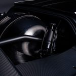 Zwart koolstofvezel drukvat met zwarte beugels en een buisvormige versteviging, ingebouwd in een compartiment met carbon panelen in de Tesla Roadster.
