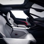 Zijaanzicht van het interieur van de Tesla Roadster met twee witte kuipstoelen, een glazen dak, alcantara hemelbekleding en rode sfeerverlichting in de deur.