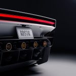 Achterkant van de Tesla Roadster met rode lichtbalk, kentekenplaat RDSTR, vier koperkleurige mondstukken en een carbon diffuser.