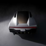 Achteraanzicht van bovenaf van de Tesla Roadster met ingeklapte spoiler, getint glazen dak, doorlopende rode lichtbalk en kentekenplaat RDSTR.