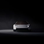 Vooraanzicht van de witte Tesla Roadster in een donkere studio, met hoekige neus, smalle ledkoplampen en getinte voorruit.