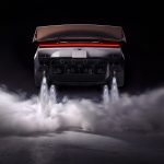 Achterkant van de Tesla Roadster met vier naar beneden gerichte stuwstralen die witte rookwolken over de grond blazen.