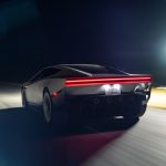 Tesla Roadster rijdt 's nachts met hoge snelheid over een baan, gezien van achteren, met rode lichtbalk en verlichte kentekenplaat RDSTR.